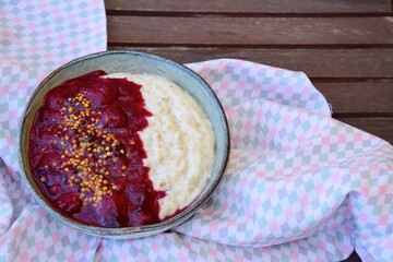 Breakfast oatmeal porridge with berry sauce and bee pollen
