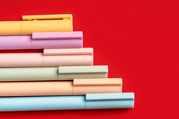Colored pens or markers on a red background