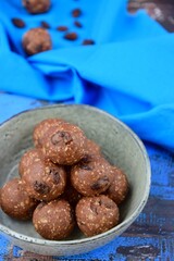 Homemade healthy energy balls with chocolate, raisin, quinoa and oat on blue background

