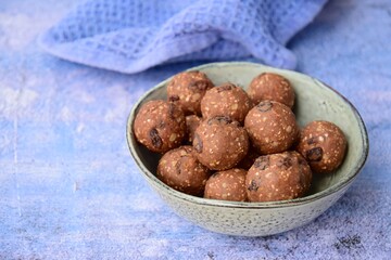 Homemade healthy energy balls with chocolate, raisin, quinoa and oat on blue background
