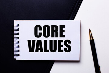 The words CORE VALUES written in red on a black and white background near the pen