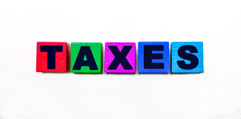 The word TAXES is written on colorful cubes on a light background