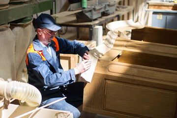 Furniture factory. The worker makes furniture. Manufacture of cabinets and shelves of wood