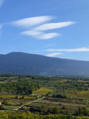 View towards Mont Ventoux, Provence from hilltop village of Crillon-le-Brave with cloud formations high above the mountain and vineyards and Provencal countryside in the foreground