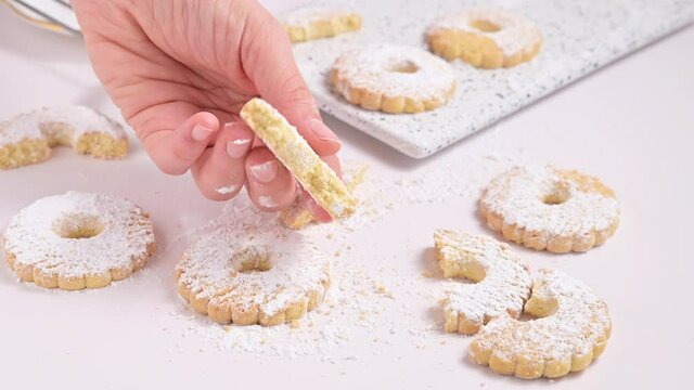 Canestrelli, traditional Ligurian chamomile-shaped cookies with powdered sugar. Holiday baked goods from the south of italy, frolla pasta in hand. Horizontal video