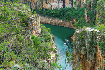 Two tourist boats navigating between the Canyons of Furnas, Capitólio MG Brazil. Landscape of eco tourism of Minas Gerais. Walls of sedimentary rocks and the green water of Lake of Furnas.