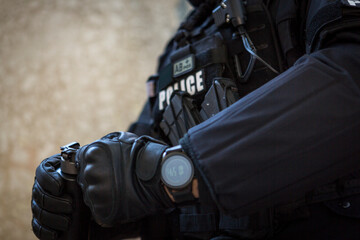 a special police officer holds a pistol, a sword and a grenade in his hands. a policeman in uniform...