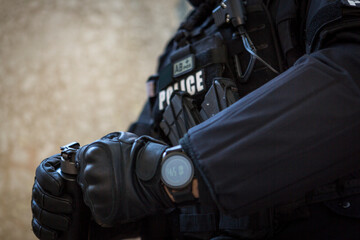 Fototapeta premium a special police officer holds a pistol, a sword and a grenade in his hands. a policeman in uniform poses in a ruined building. a special policeman in full combat gear ready for a mission and a task.