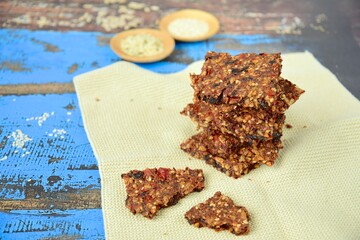 Seed crackers made from bell pepper, sun dried tomato, sunflower seed, sesame seed, hemp seed and flax seeds. Selective focus