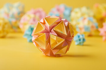 Set of multicolor handmade modular origami balls or Kusudama Isolated on yellow background. Visual...