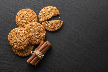 oatmeal cookies with grains and cinnamon on a stone background