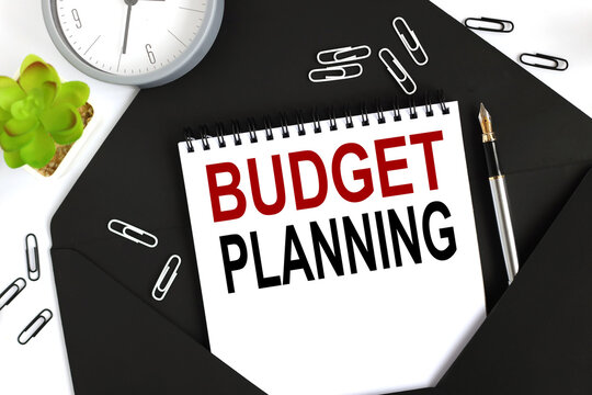 BUDGET PLANNING. text on a sheet of notepad on a black envelope on a light background