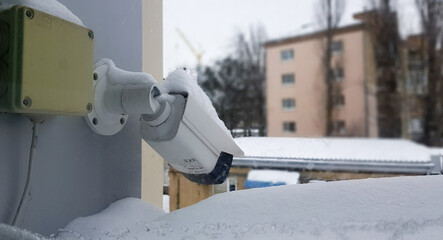 Large white surveillance camera over a window against the backdrop of a public building. close-up....