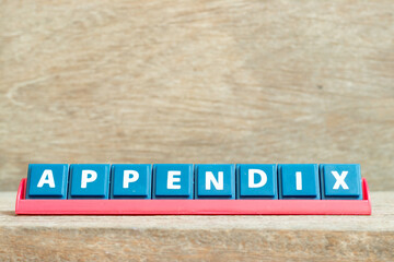 Obraz premium Tile alphabet letter with word appendix in red color rack on wood background