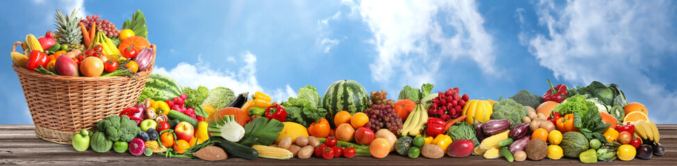Assortment of fresh organic fruits and vegetables on wooden table outdoors. Banner design