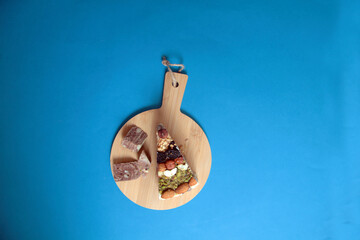 a piece of sherbet pie on cutting board isolated on blue background flat lay. Turkish sweet concept