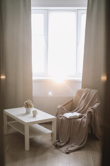 Cozy interior of the living room with coffee table and armchair by the window. 