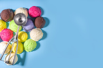 Colorful various ice cream scoops pattern on pastel blue background. Summer minimalism pattern flat lay with hard light. Chocolate vanilla blueberry strawberry pistachio orange ice-cream balls top vie