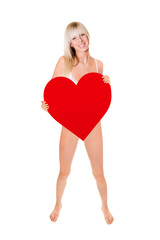 Full length portrait of a beautiful blonde woman wearing white lingerie and holding a big red heart, studio photo isolated in front of white background