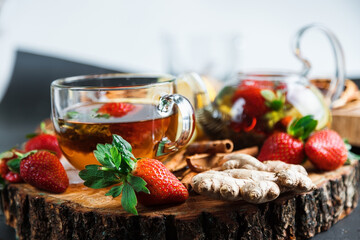 Fruit red tea with wild berries in a glass cup, on a wooden table, on a dark background