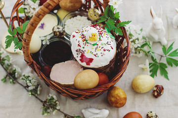 Stylish easter eggs, homemade Easter bread, traditional Easter food in  basket on rustic table