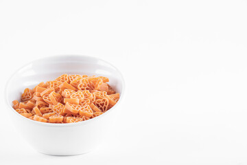 Bowl of raw heart shaped pasta on white background
