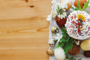 Delicious homemade Easter bread, stylish easter eggs, spring flowers on rustic table. Happy Easter