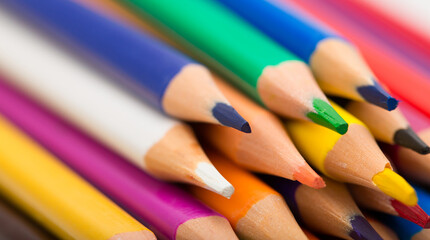 Creation Multicolored pencils on a blank white sheet. On a white background.