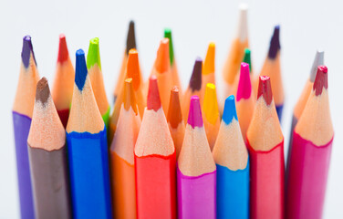 Creation Multicolored pencils on a blank white sheet. On a white background.