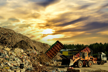 Garbage truck unloads construction waste from container at the landfill. Recycling waste concrete ...
