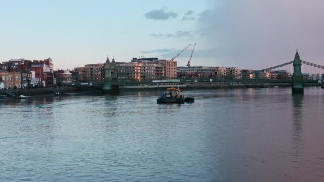 Low drone shot over river thames and Hammersmith bridge evening