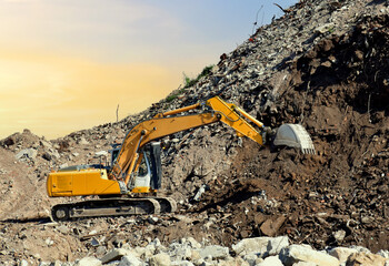 Recycling concrete and construction waste from demolition. Excavator at landfill of the disposa....