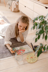 Portrait of a young woman painting at home