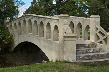 stone bridge over a grass meadow