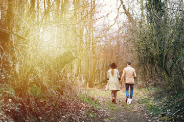 Young beautiful caucasian couple walking holding hands