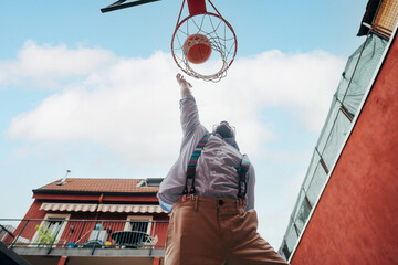 Young mixed race man outdoor dunking playing basketball