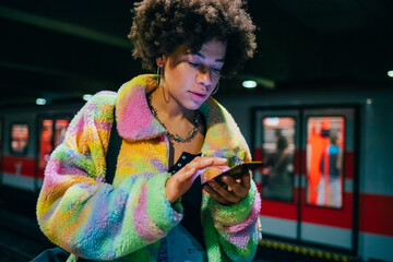 Young beautiful multiethnic woman metro station using smartphone