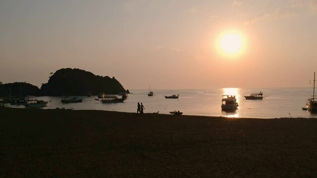 Morning on the beach in the village of Cirali, fishing nets lie on the yellow sand. Boats and ships in the distance of the Taurus mountain are moored near the shore. Landscapes of the Lycian Trail.