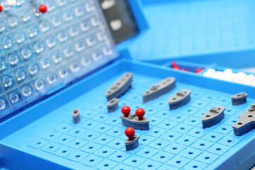 Toy war ships and submarine are placed on the playing Board in the game battleship