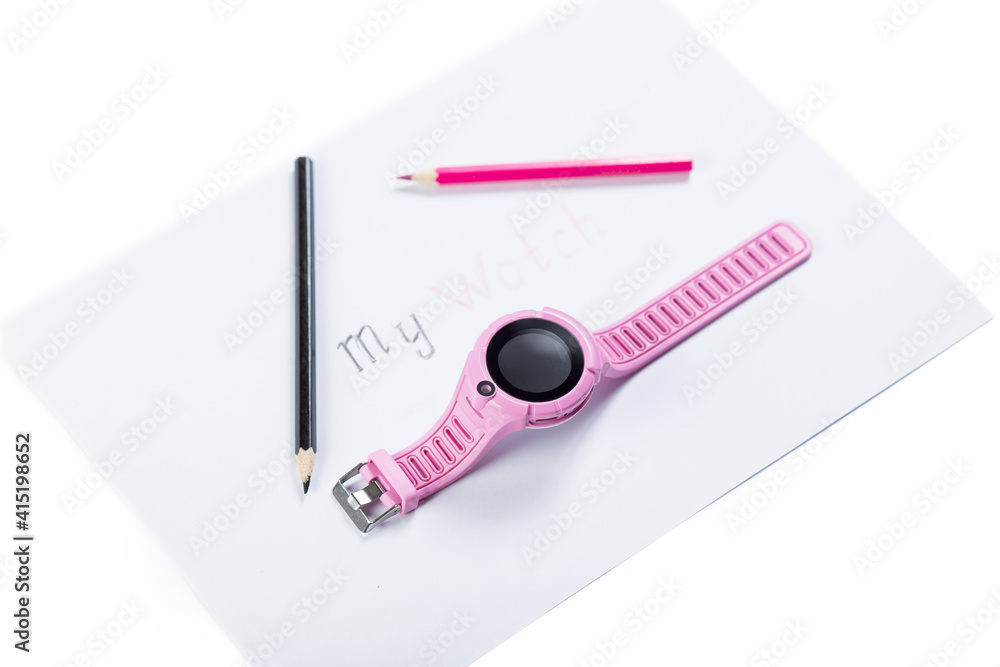 Wall mural Chindren's smart watch. GPS watch for kids. Pink watch on piece of paper with pencils.