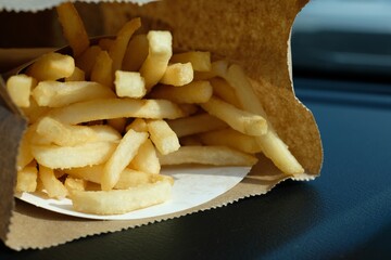 close-up French fries in paper bag on black background