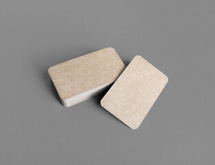 Photo of blank kraft business cards on gray paper background. Mock-up for branding identity.