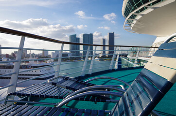 Outdoor pool deck with sun loungers and deck chairs on modern cruiseship or cruise ship liner in...