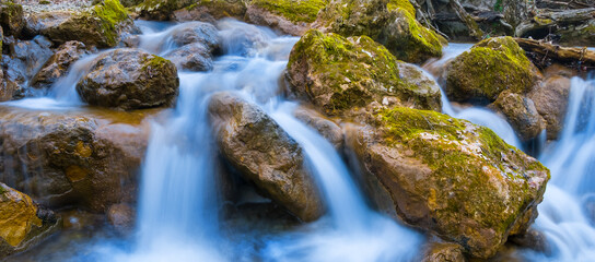 Naklejka na ściany i meble closeup small waterfall on the mountain river, outdoor mountain canyon scene