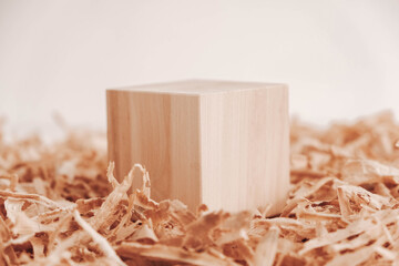 One wooden block on a background of carpentry shavings. Copy, empty space for text