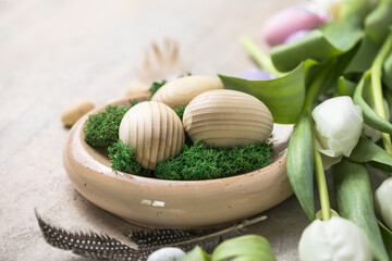 Easter composition with wooden Easter eggs and spring flowers  tulips on concrete background. Easter card close up