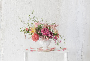 bouquet of summer flowers in vase on vintage white wooden shelf on white background
