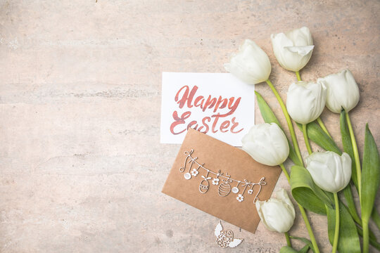 White  tulips, Happy Easter cards on gray background. Top view flat lay