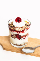 Muesli with raspberries and yogurt in a glass with a spoon.