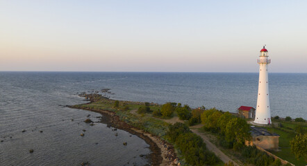 Aerial shot of a lighthouse on the Kihnu island in Estonia during a beautiful sunset